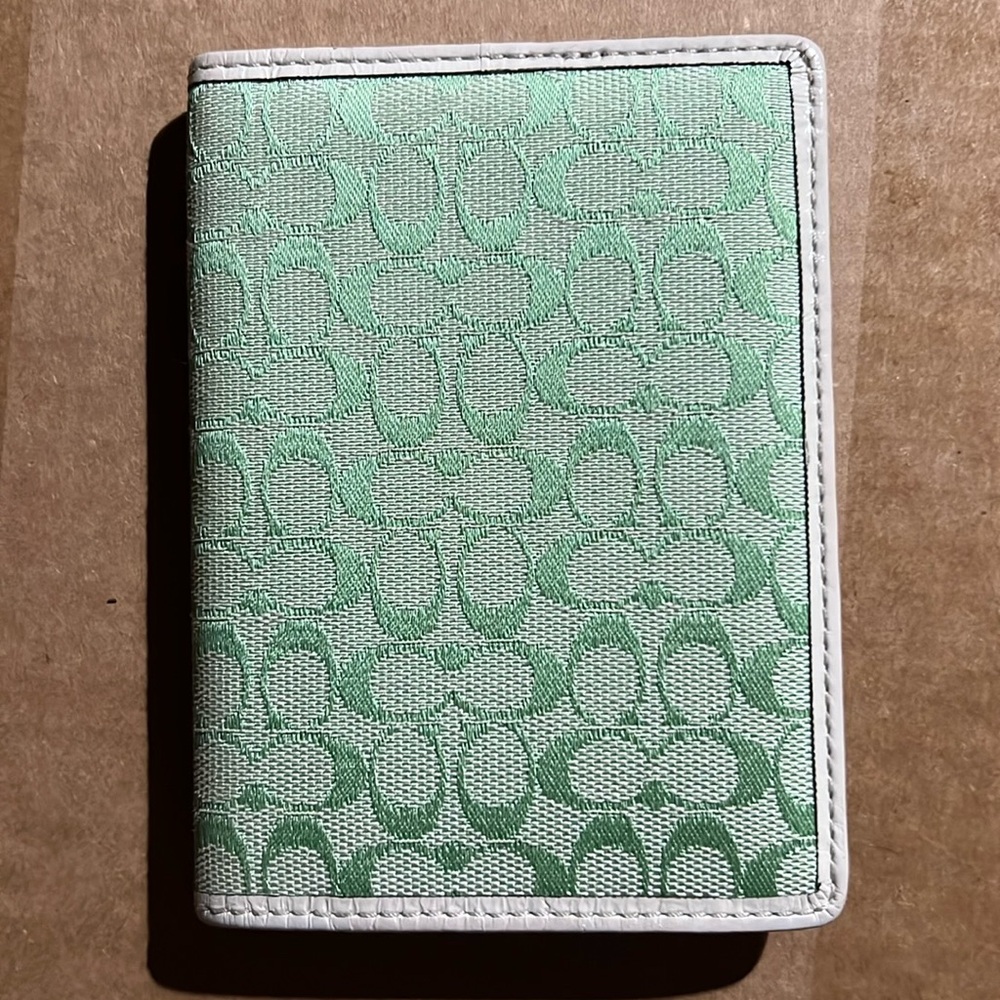 Coach brand passport holder. Green signature logo print with cream leather.